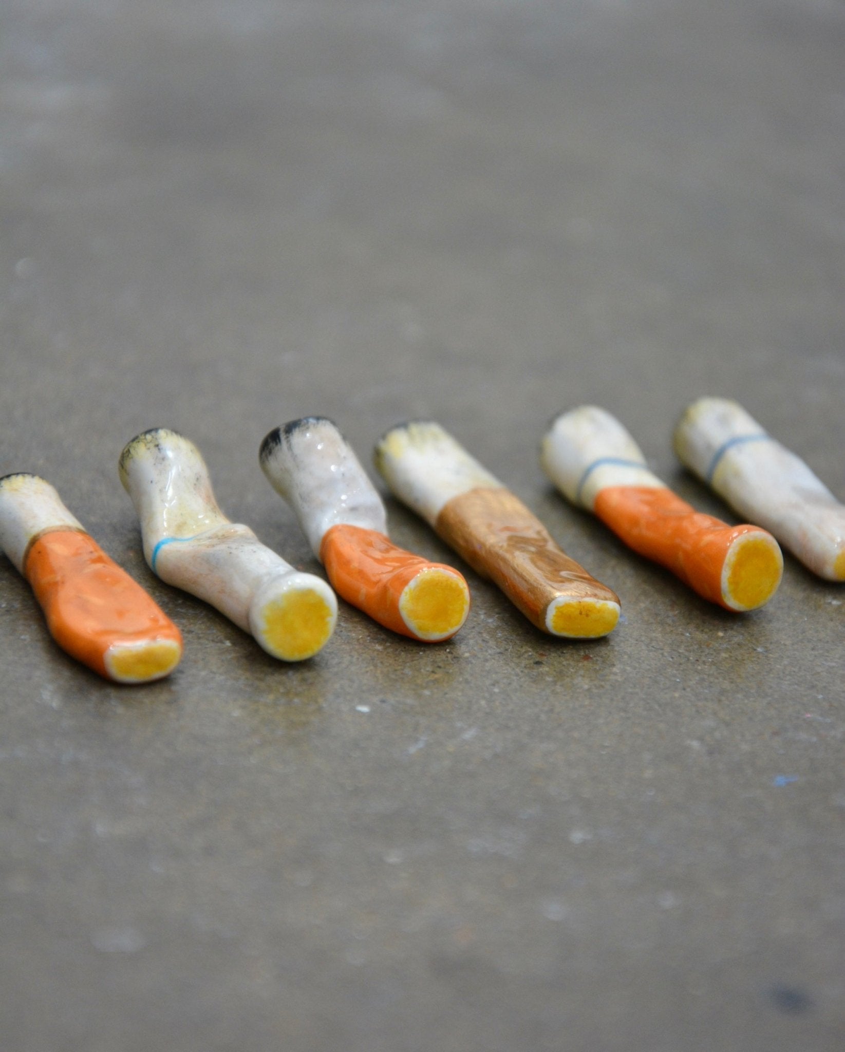 cigarette stompie Servicing & Lease Options Details Set features a gold cigarette butt Each cigarette is crushed or flattened to look like it has been stepped on and kicked aside Cigarette Butt Stomp